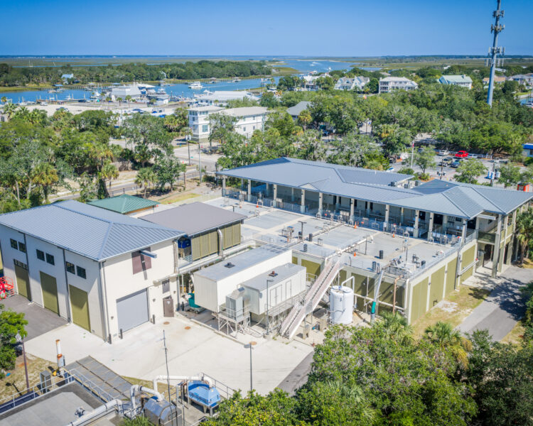 Aerial view of marine research facility by marina with boats.