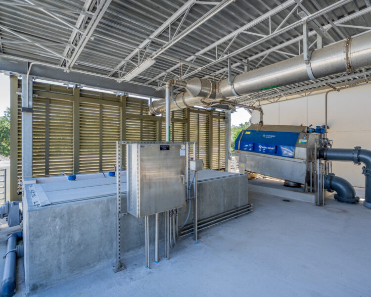 Water treatment machines, pipes, and panels on a concrete floor.