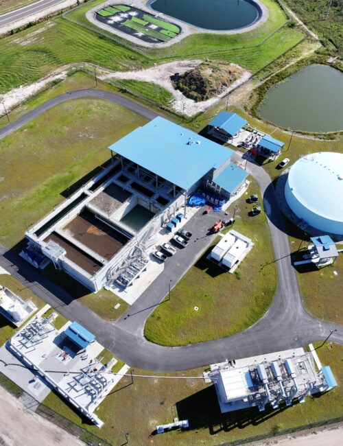 Aerial view of water treatment facility with tanks and ponds.
