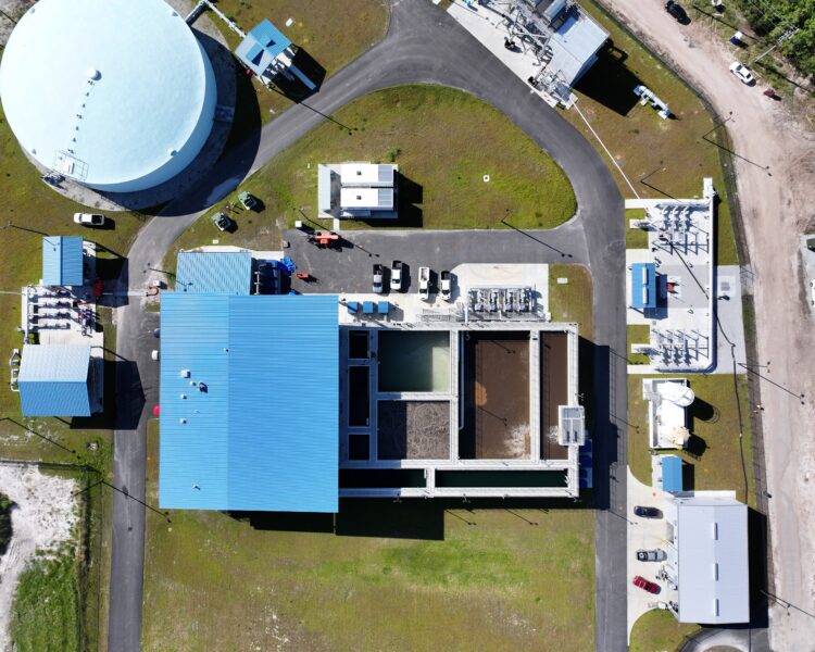 Aerial view of water treatment plant with blue-roofed buildings.