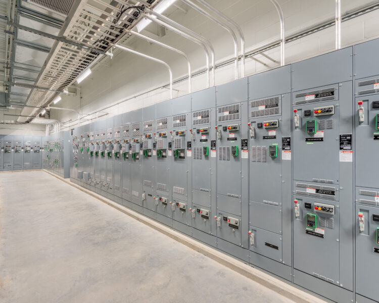 Cuadros de control industriales con interruptores y pantallas en unas instalaciones limpias.