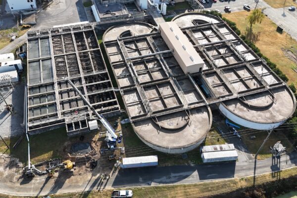 Vista aérea de una planta de tratamiento de aguas residuales con depósitos y equipos.