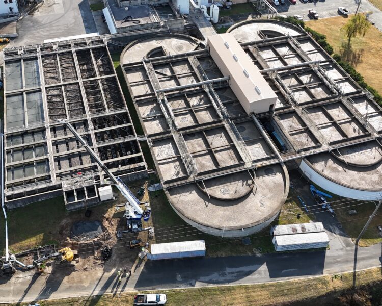 Vista aérea de una planta de tratamiento de aguas residuales con depósitos y equipos.