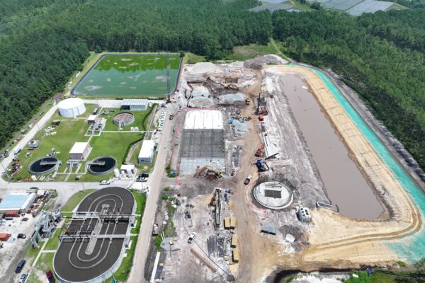 Vista aérea de una planta de tratamiento de aguas residuales, con depósitos, edificios y obras en las inmediaciones.