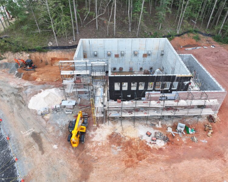 Aerial view of construction site with concrete walls and trees.