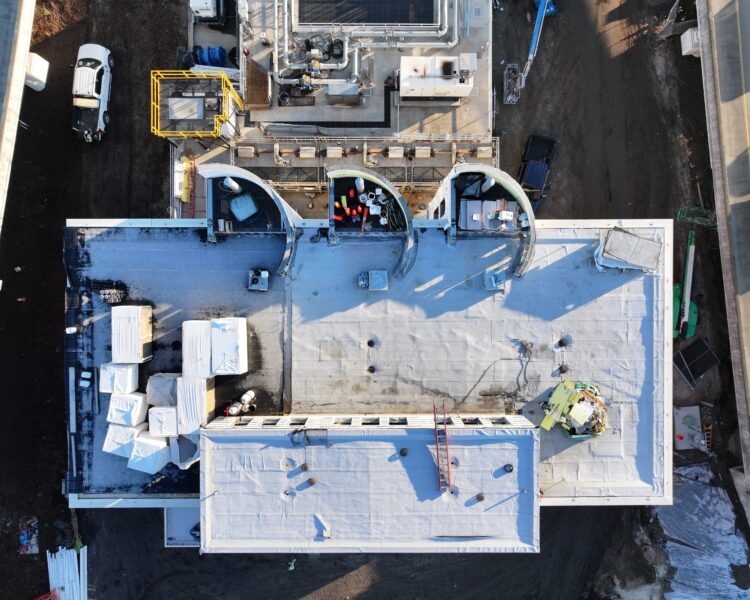 Aerial view of building under construction, equipment and workers visible.