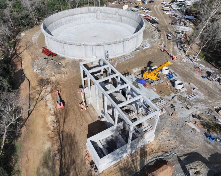 Aerial view: circular tank, rectangular frame, equipment, and vehicles.