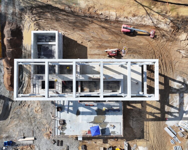 Aerial view of a muddy construction site and unfinished building.