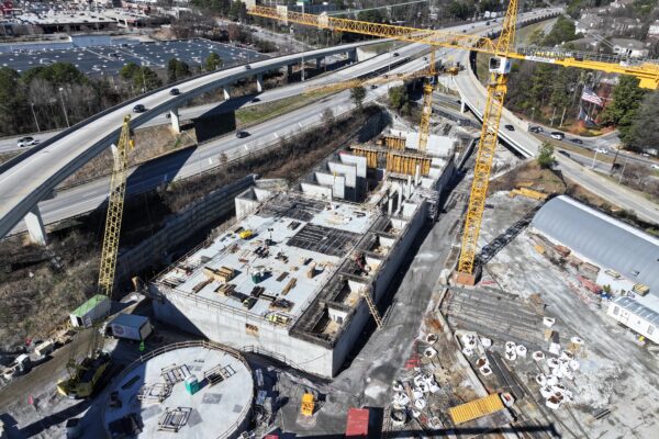 Vista aérea de grúas y hormigón en una obra de construcción de una autopista.