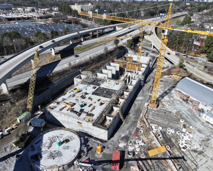 Aerial view of cranes and concrete at a highway construction site.