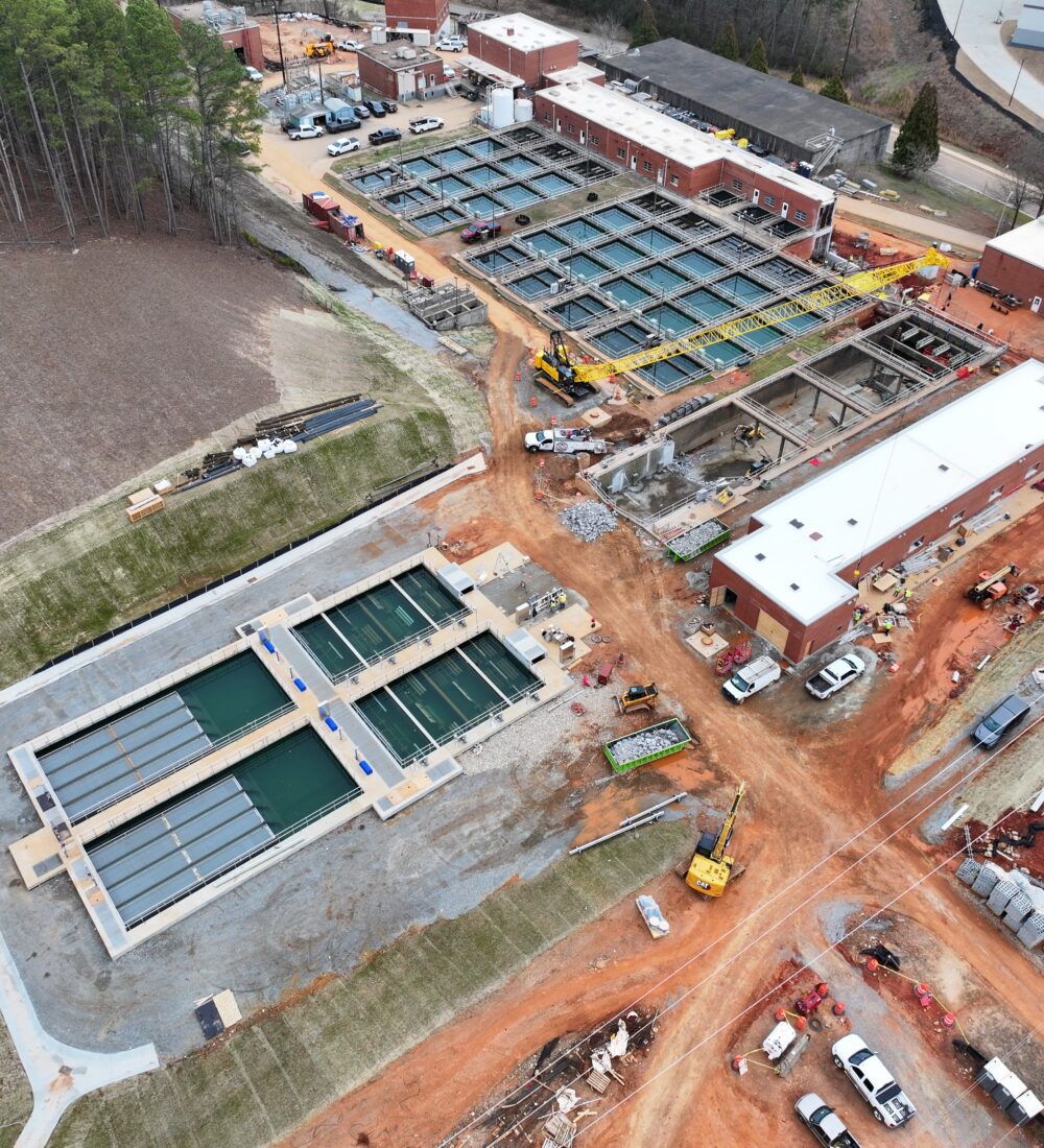 Aerial view of water treatment plant under construction with equipment.