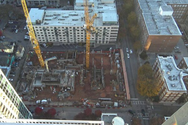Vista aérea de una obra con grúas en una ciudad.