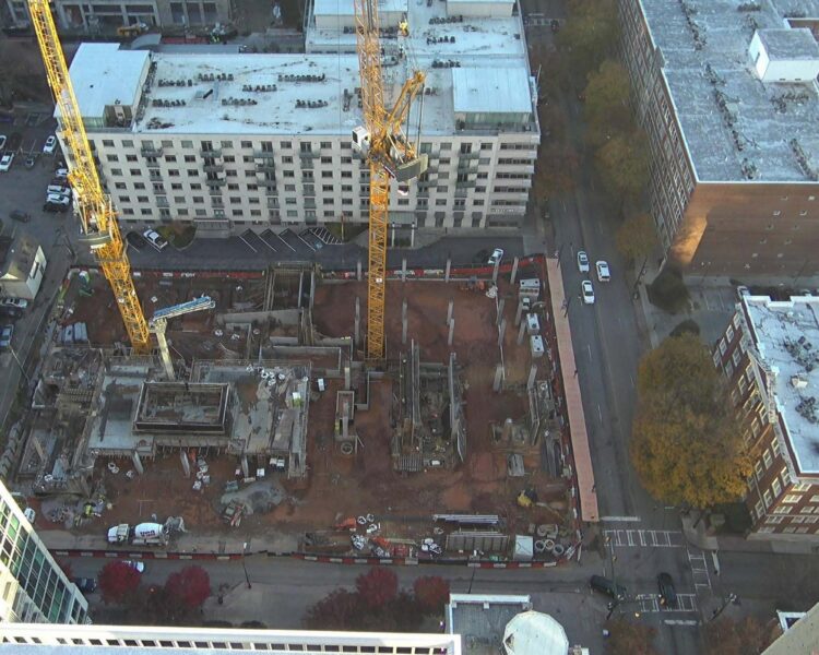 Aerial view of construction site with cranes in a city.