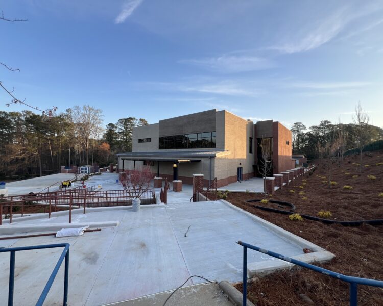 Modern two-story brick building with large windows and walkway.
