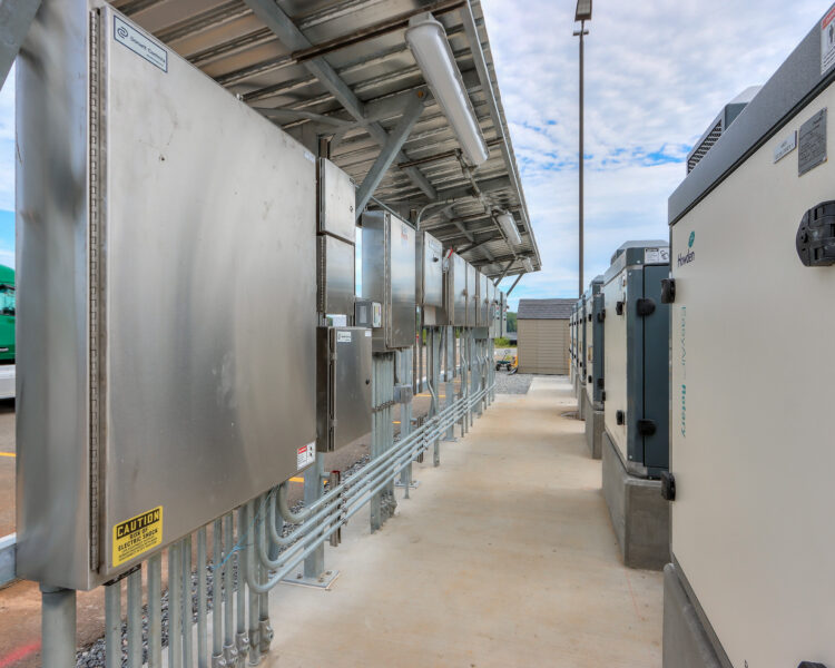 Cuadros de control industriales para exteriores y equipos situados bajo una marquesina metálica.