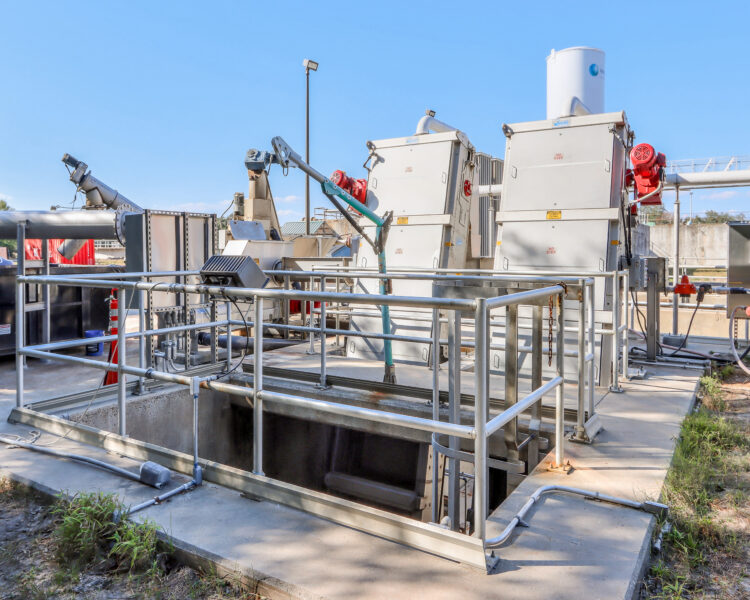 Planta de tratamiento de aguas industriales con barandillas metálicas y maquinaria.