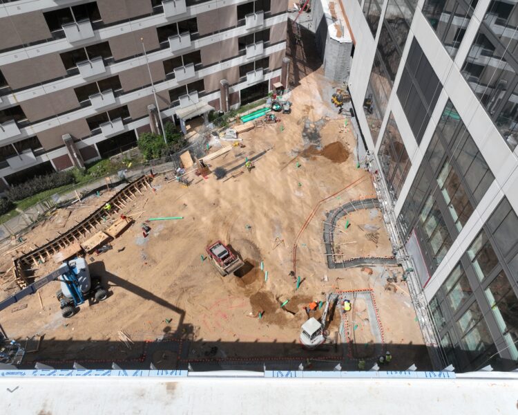 Aerial view of construction site with workers, machines, and dirt.