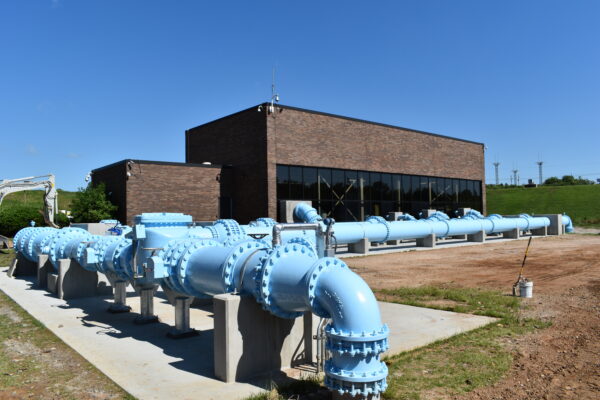Edificio industrial de ladrillo con grandes tuberías y válvulas azules en el exterior.