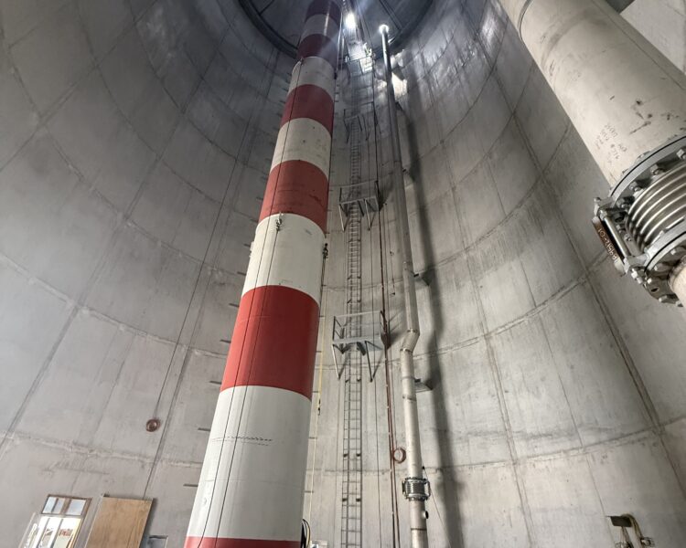Industrial interior with striped column, pipes, ladder, and caution tape.