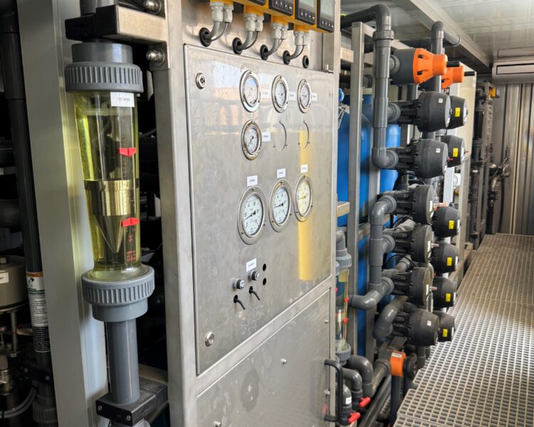 Cuadro de control industrial con indicadores, medidores, tuberías y conductos.