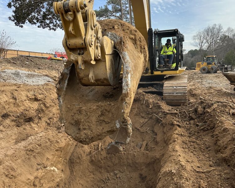 Un trabajador utiliza una excavadora amarilla para mover tierra en el exterior.