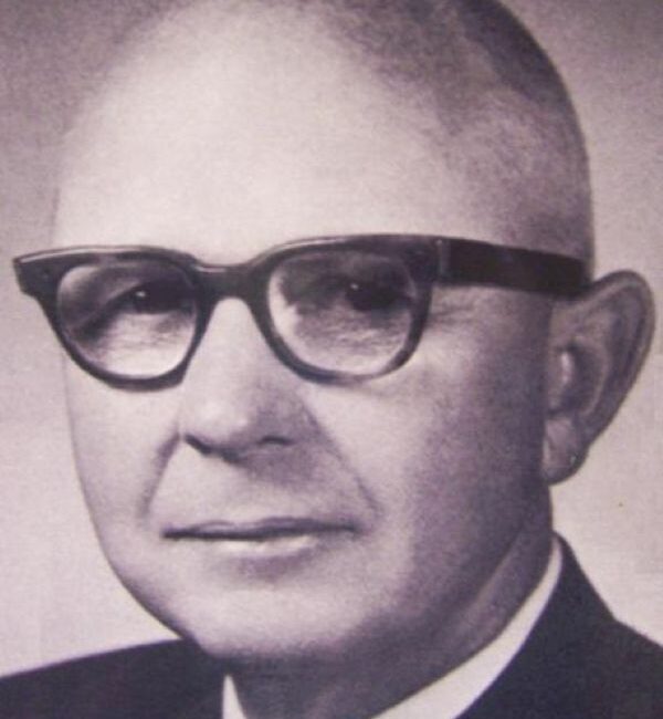 Older man in suit and glasses, black and white portrait.