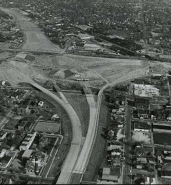 Black-and-white aerial view of highway interchange construction site.